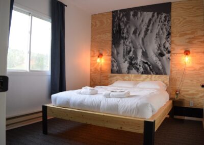 Bedroom featuring white bedding and mountain print art work on the wall